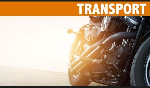 A black motorcycle three-quarter view on the beach in the light of sunset