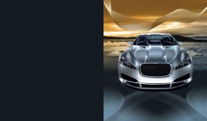 Silver luxury sedan with very low bumper and icy lake at orange sunset